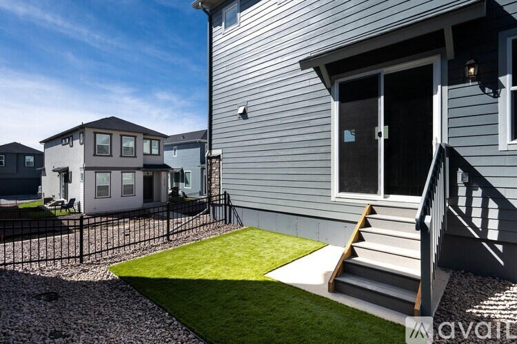 A house with a grey siding exterior and a black metal fence.