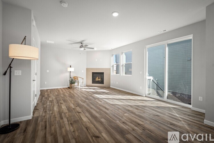 A spacious living room with wood flooring and a fireplace.