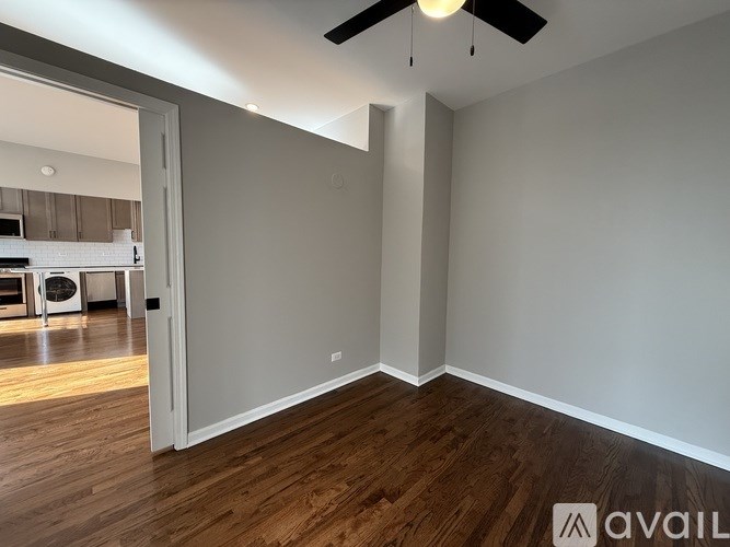 A room with a ceiling fan and wooden flooring.