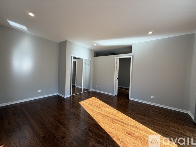 A room with wooden flooring and white walls.