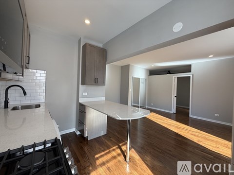 A modern kitchen with a stove top oven and a table.