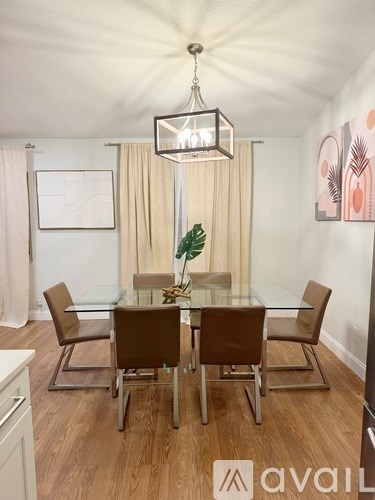 A modern dining room with a glass table and chairs.