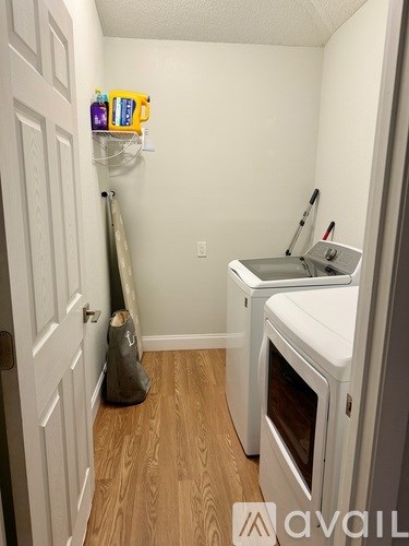 A small kitchen with a white oven and a white door.