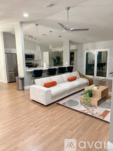 A living room with a white couch and a wooden coffee table.