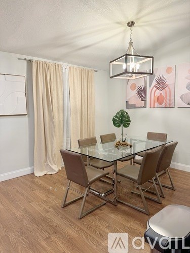 A modern dining room with a glass table and chairs.