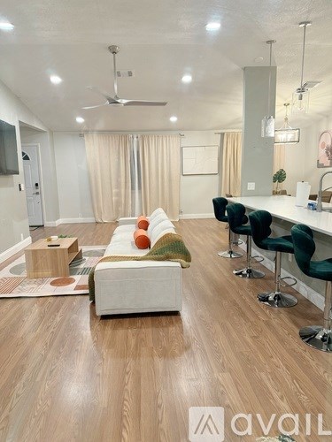 A living room with a white couch and a wooden floor.