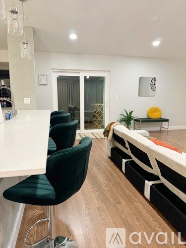 A room with a white desk, black chairs, and a white couch with black and white stripes.