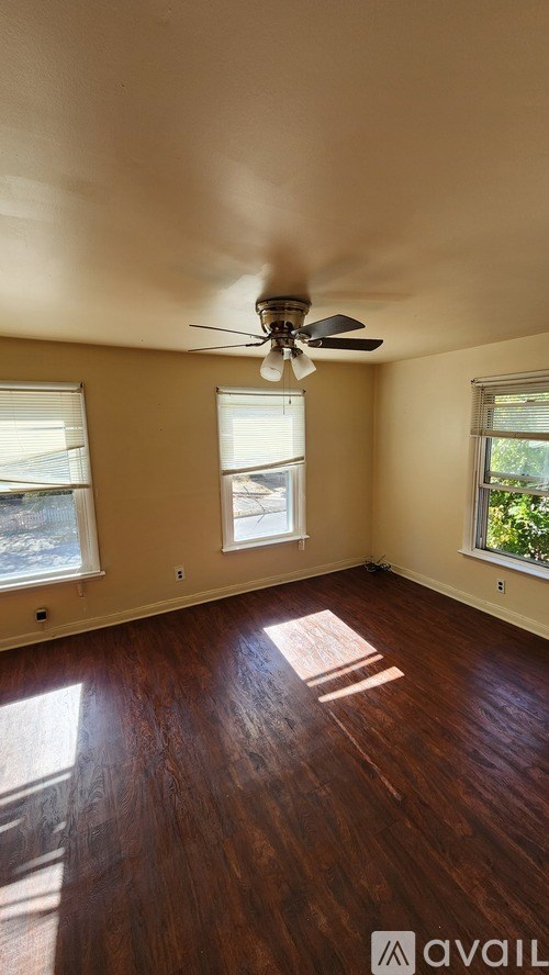 A room with wooden floors and a ceiling fan.