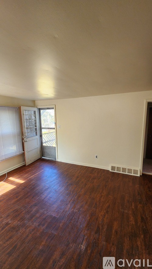 A room with wooden floors and a sliding glass door.