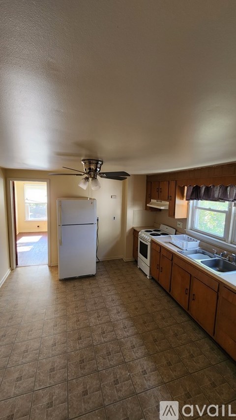 A kitchen with a refrigerator, stove, and sink.