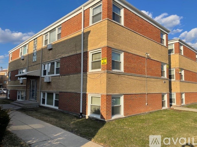 A brick apartment building with a clear blue sky in the background.