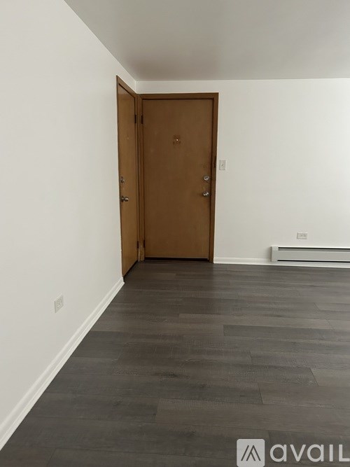 A room with a wooden door and grey flooring.