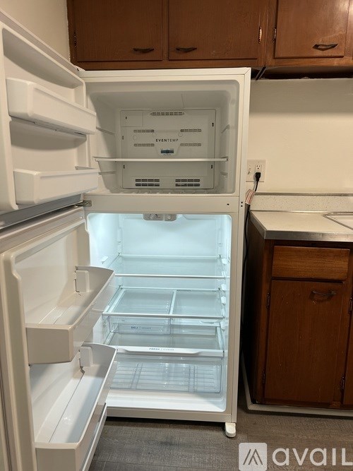 A white refrigerator with its door open in a kitchen.