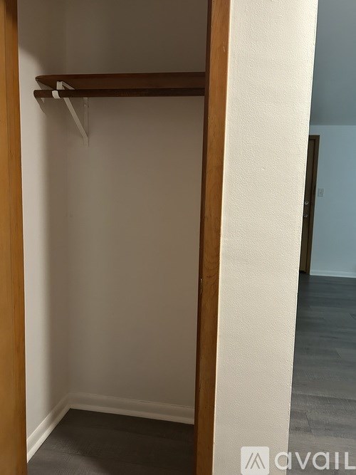 A white wall with a wooden door frame and a white door.