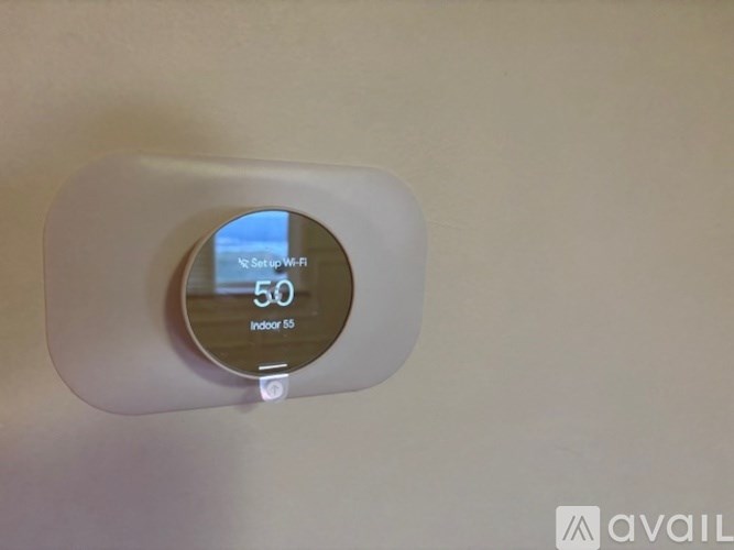 A device mounted on a wall showing a temperature of 50 degrees.