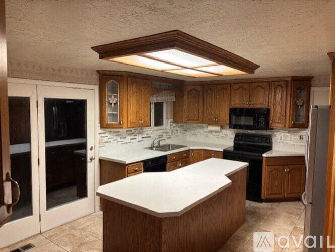 A kitchen with wooden cabinets and a white countertop.
