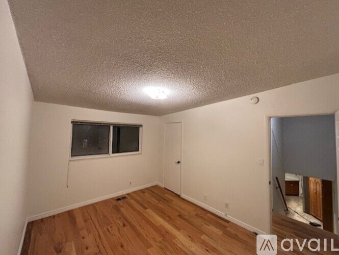 A room with wooden floors and a window.