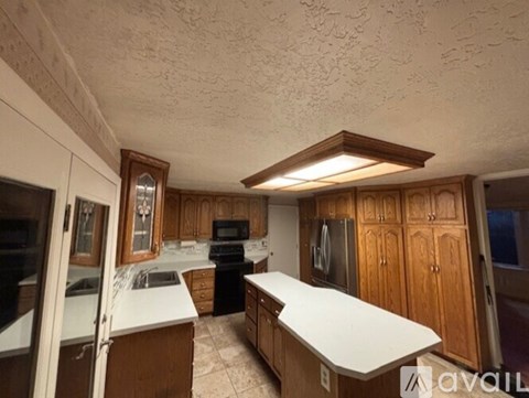 A kitchen with wooden cabinets and a white countertop.