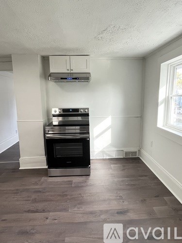 A kitchen with a stove, oven, and a window.
