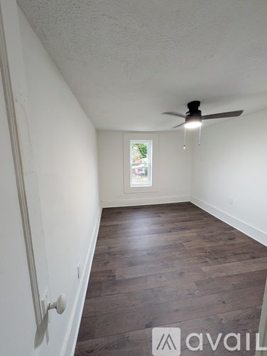 A room with a ceiling fan and a window.