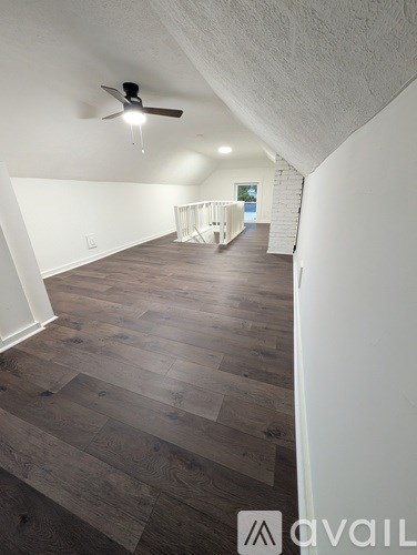 A room with wooden flooring and a ceiling fan.