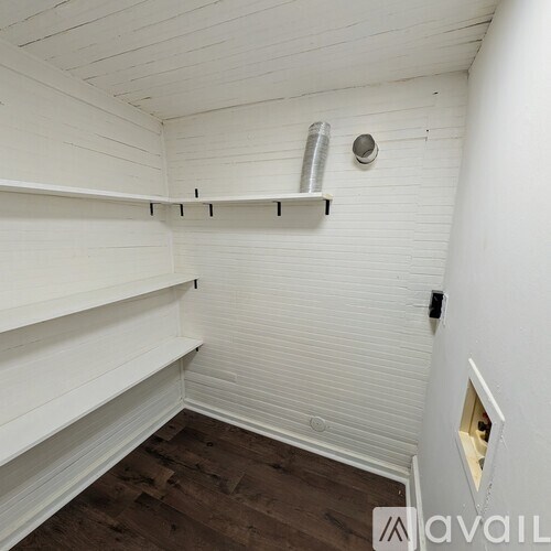 A white room with wooden floors and white walls.