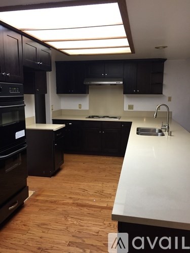 A kitchen with black cabinets and a white countertop.