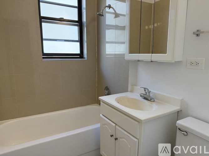 A white bathroom with a tub, sink, and mirror.