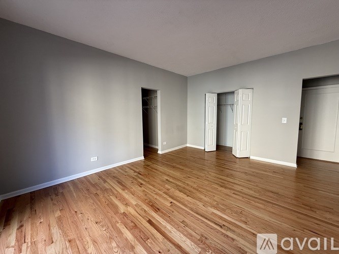 A room with wooden flooring and white walls.