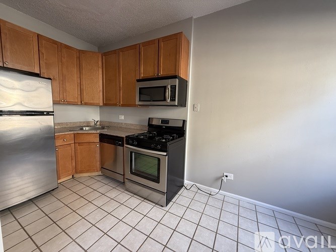 A kitchen with a refrigerator, microwave, oven, and stove.