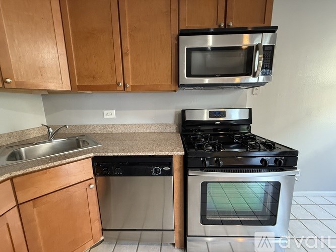 A kitchen with a black stove top oven and a black microwave above it.