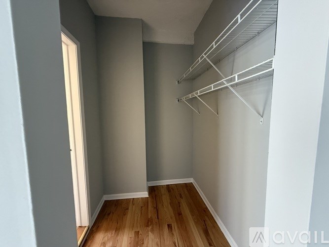 Empty room with white walls and wooden floor.