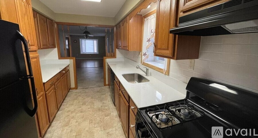A kitchen with a black stove top oven and a sink with a faucet.