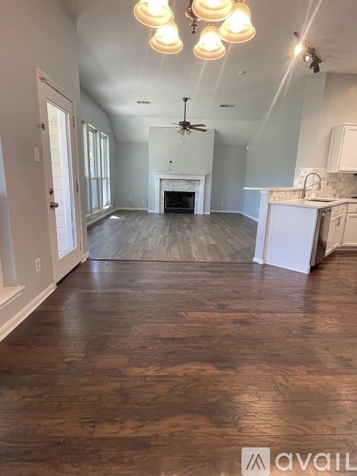 A spacious room with a fireplace and a kitchen area.