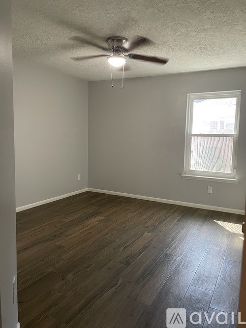 A room with a ceiling fan and a window.