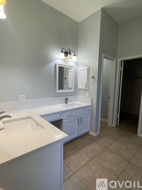 A bathroom with a sink, mirror, and cabinets.