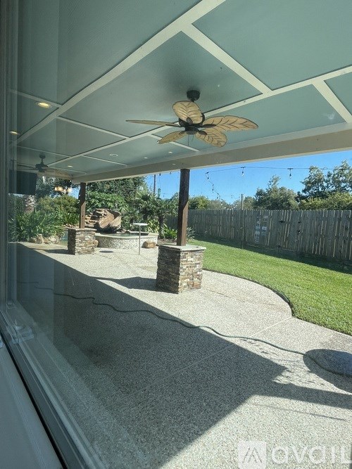 A fan is on the patio of a house.