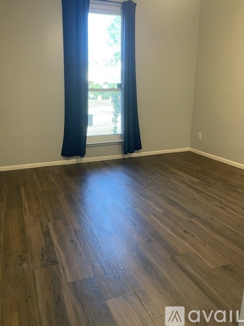 A room with a window and a blue curtain.