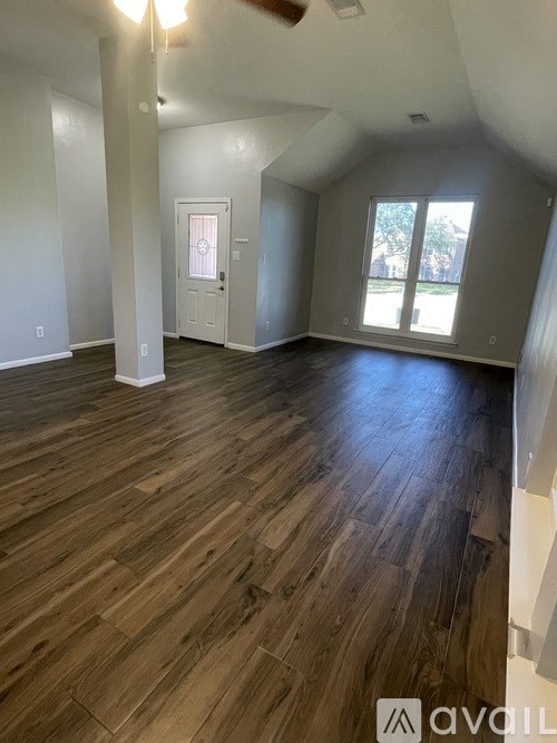 A room with wooden flooring and a white door.