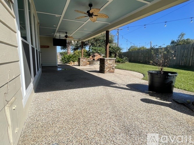 A patio with a ceiling fan and a trash can.