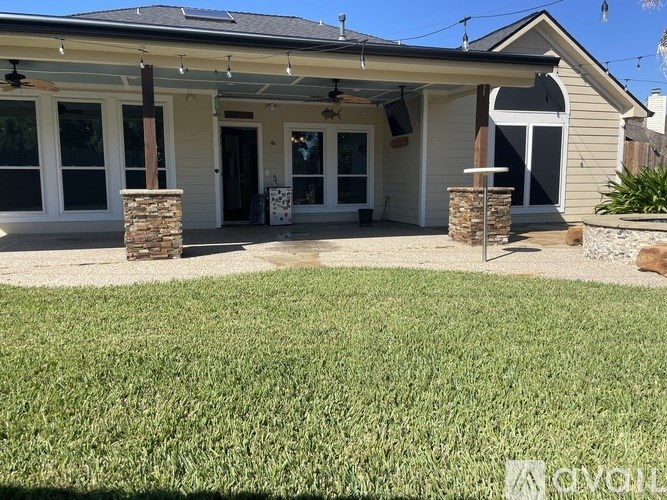 A house with a covered patio and a stone pillar.