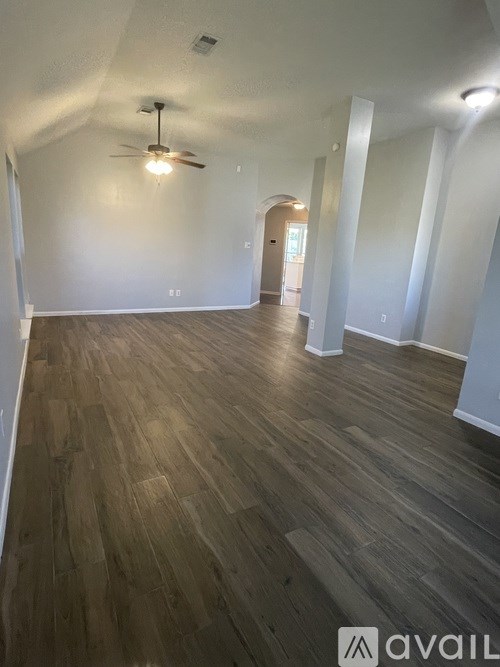 A room with wooden flooring and a ceiling fan.