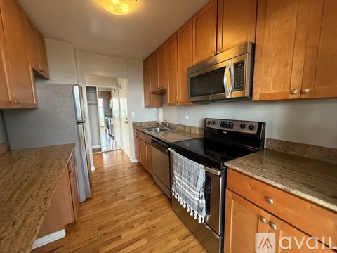 A kitchen with wooden cabinets and a black stove top oven.