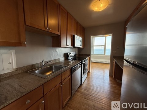 A kitchen with wooden cabinets and a stainless steel refrigerator.