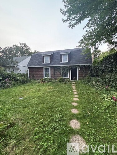 A house with a green lawn and a path leading to it.