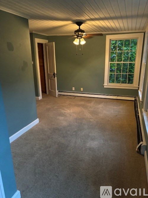 A room with a ceiling fan and a window.