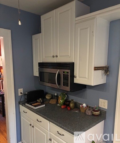 A kitchen with white cabinets and a granite countertop.