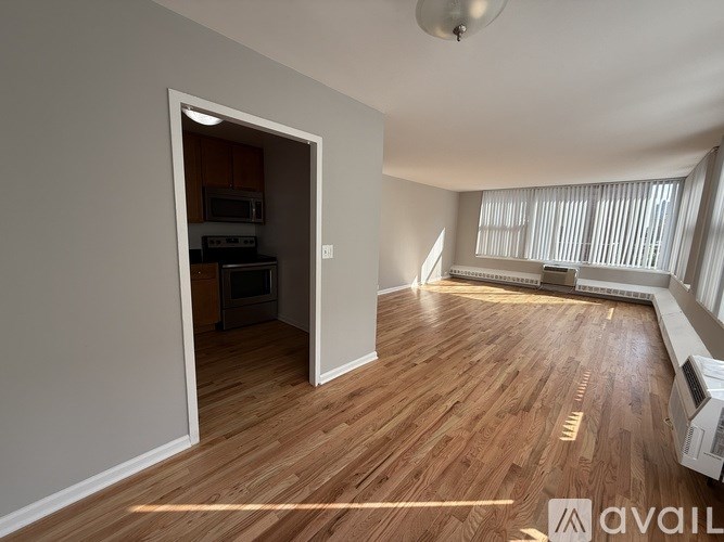 A room with wooden flooring and a white ceiling with a light fixture.