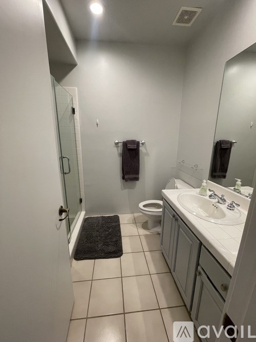 A bathroom with a toilet, sink, and mirror.