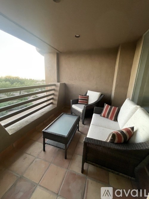 A balcony with a table and chairs.